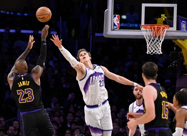 Lakers star LeBron James, left, shoots as Utah Jazz forward...
