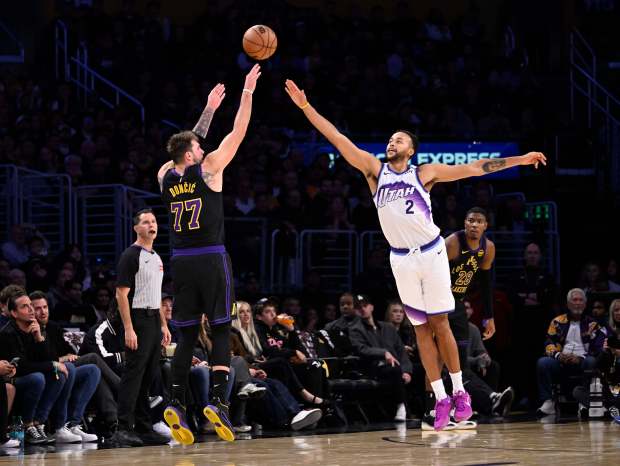 Lakers star Luka Doncic takes a 3-point shot as the...