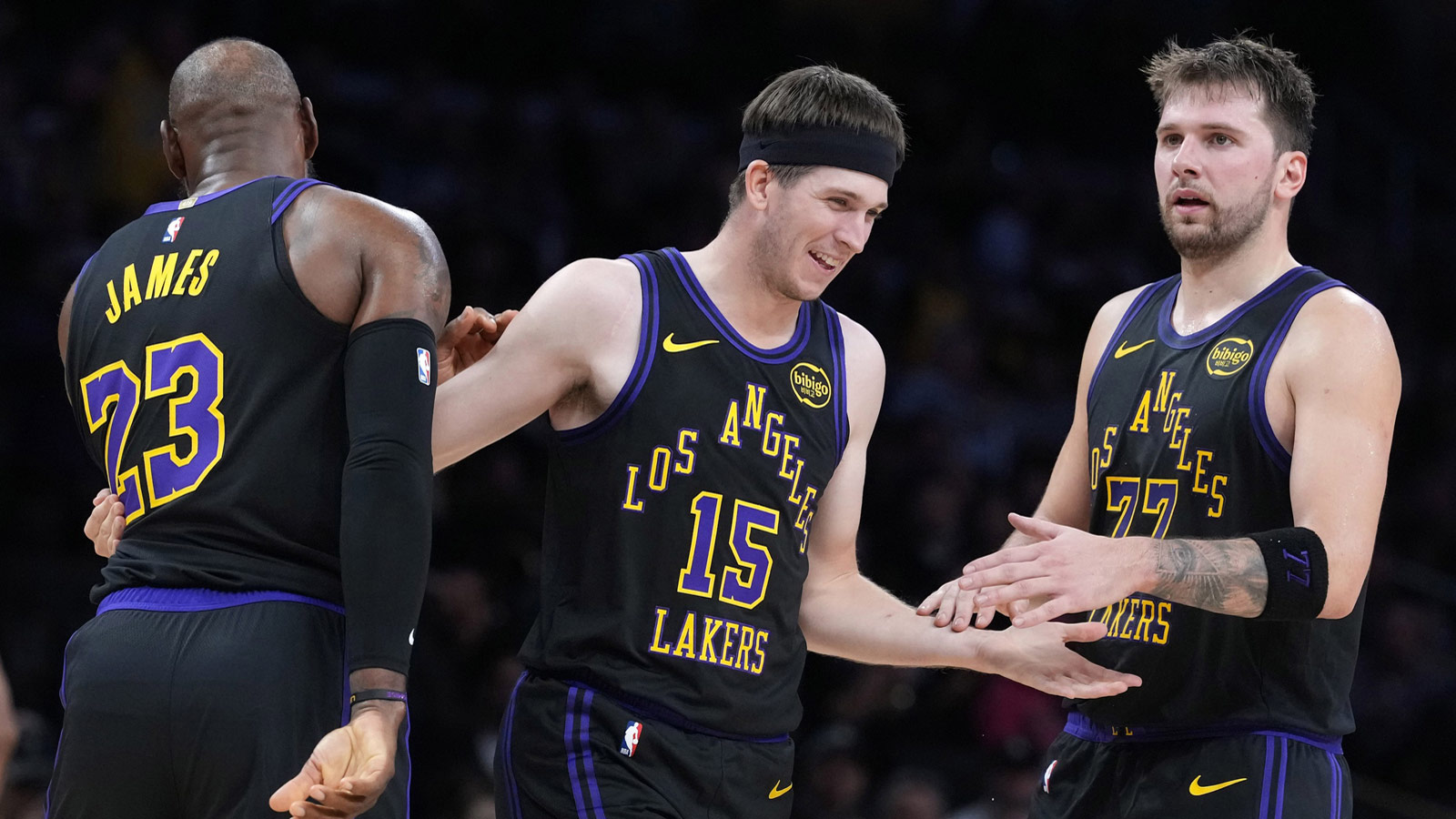 Lakers guard Austin Reaves (15) is congratulated by forward LeBron James (23) and guard Luka Doncic (77) after a three-point basket in the second quarter at Crypto.com Arena