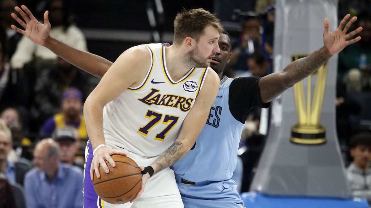 Los Angeles Lakers guard Luka Doncic (77) handles the ball as Memphis Grizzlies forward Vince Williams Jr. (5) defends during the fourth quarter at FedExForum. 