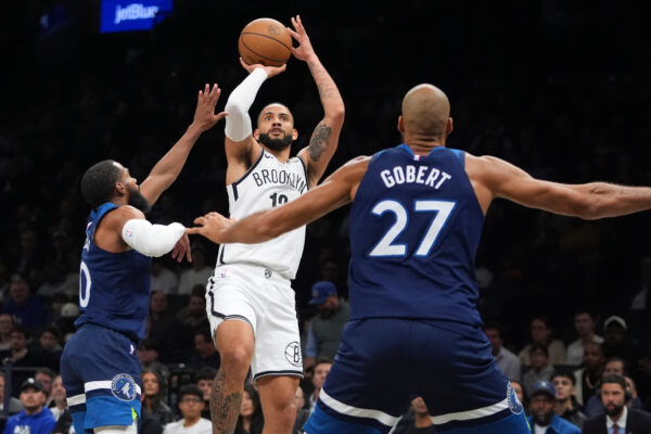 Brooklyn Nets' Tyrese Martin, center, shoots over Minnesota Timberwolves' Mike Conley, left, and Rudy Gobert during the first half of an NBA basketball game Monday, Nov. 3, 2025, at Barclays Center in New York. (AP Photo/Frank Franklin II)