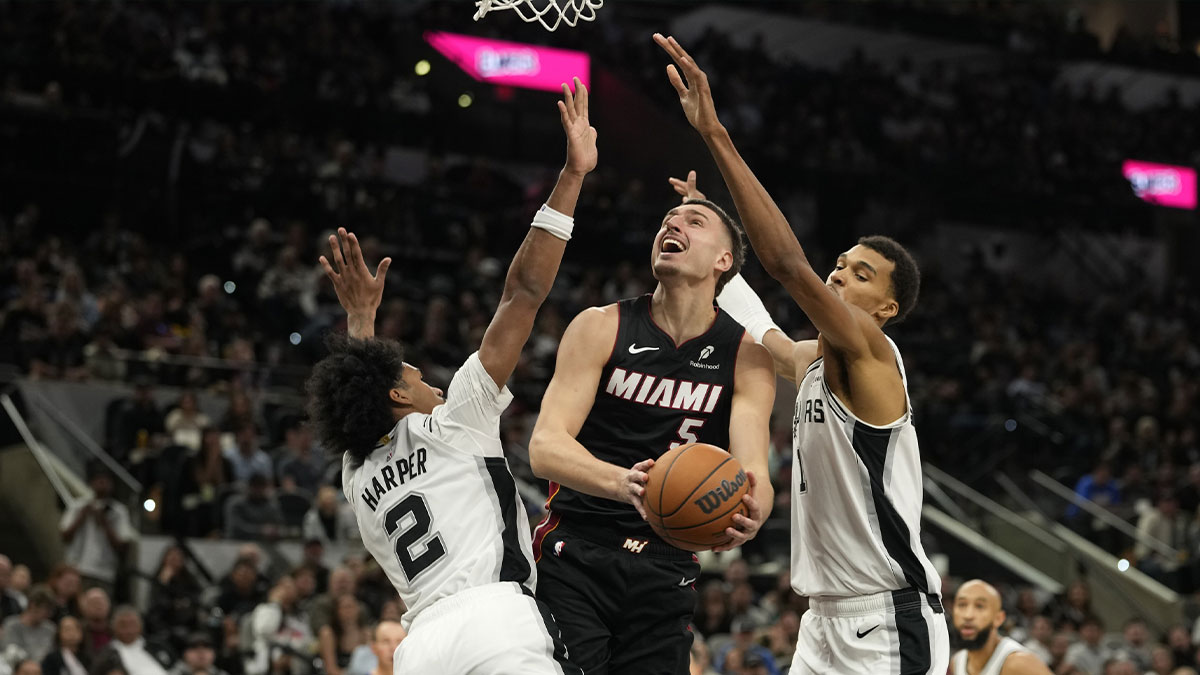 Miami Heat forward Nikola Jovic (5) drives to the basket between San Antonio Spurs guard Dylan Harper (2) and forward Victor Wembanyama (1) during the second half at Frost Bank Center.