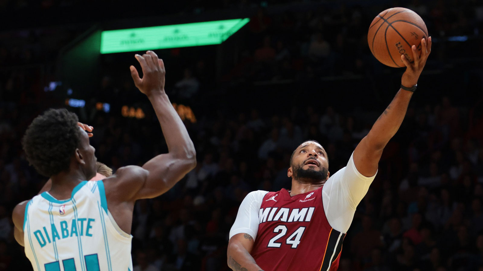 Miami Heat guard Norman Powell (24) lays up a shot against Charlotte Hornets forward Moussa Diabate (14) during the third quarter of an NBA Cup game at Kaseya Center. 
