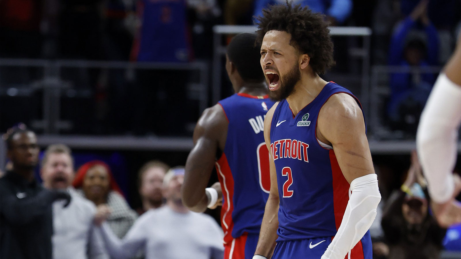 Pistons guard Cade Cunningham (2) celebrates in overtime against the Washington Wizards at Little Caesars Arena with the Cavs logo in the background