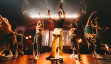 Photo of a singer on stage surrounded by dancers.