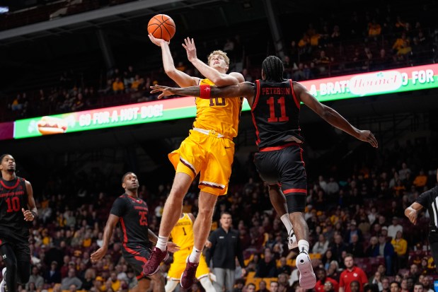 Minnesota guard Cade Tyson (10) is fouled by Gardner-Webb forward NaVuan Peterson (11) while shooting during the first half of an NCAA college basketball game Monday, Nov. 3, 2025, in Minneapolis. (AP Photo/Abbie Parr)