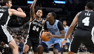 Memphis Grizzlies guard Vince Williams Jr. (5) drives against San Antonio Spurs guard Devin Vassell (24) and Spurs center Luke Kornet (7) during the first half of an NBA basketball game, Tuesday, Nov. 18, 2025, in San Antonio. (AP Photo/Darren Abate)