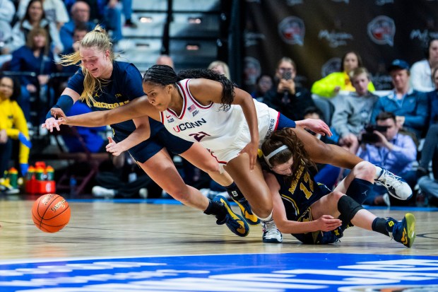 Michigan's Olivia Olson (1) and UConn's Sarah Strong go for the loose ball during the first half of an Invesco QQQ Basketball Hall of Fame Women's Showcase game at Mohegan Sun on Nov. 21, 2025 at Mohegan Sun. (Joe Buglewicz/Getty Images)