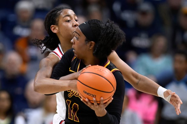 UConn guard KK Arnold pressures Loyola Chicago guard Kendall Hendrix, right, in the first half of an NCAA college basketball game, Wednesday, Nov. 12, 2025, in Storrs, Conn. (AP Photo/Jessica Hill)