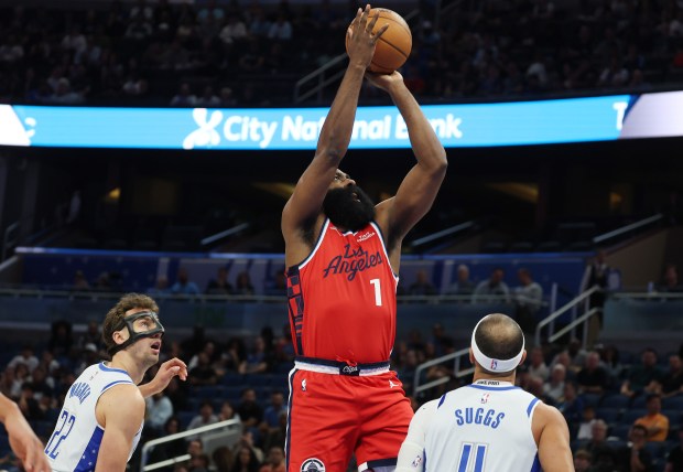 LA guard James Harden (1) shoots between Orlando players Franz...