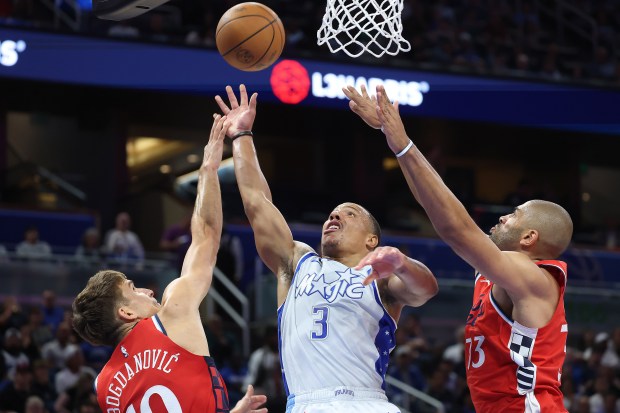Orlando guard Desmond Bane (3) shoots between LA defenders Bogdan...
