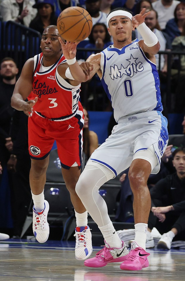 LA guard Chris Paul grabs the arm of Orlando guard...