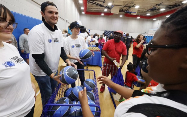 Orlando Magic staffers hand out basketballs during a Thanksgiving Celebration...