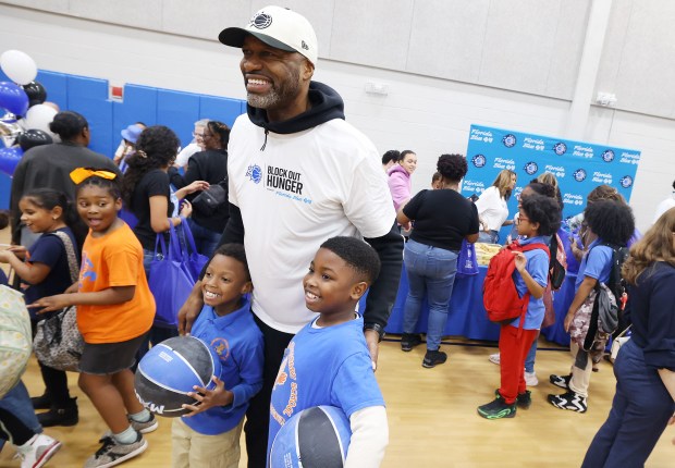 Orlando Magic head coach Jamahl Mosley poses with kids as...