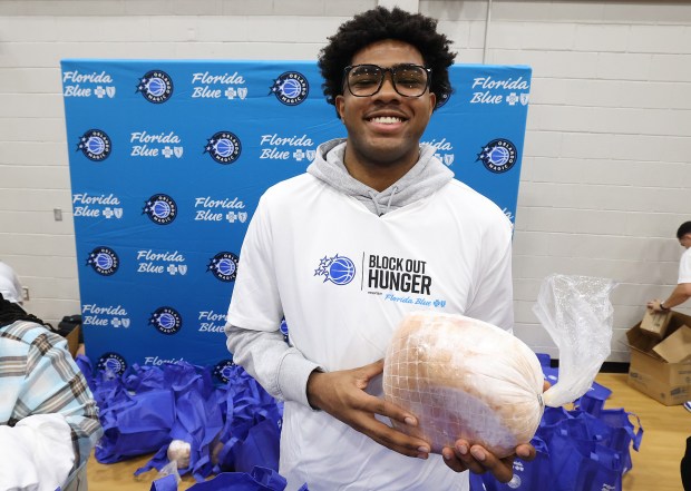 Orlando Magic guard Jase Richardson holds a frozen turkey during...