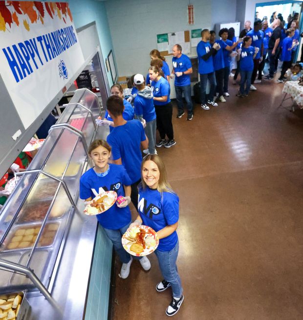 A THANKSGIVING TRADITION — Volunteers Kyler Jenkinson and Michelle DeVos...