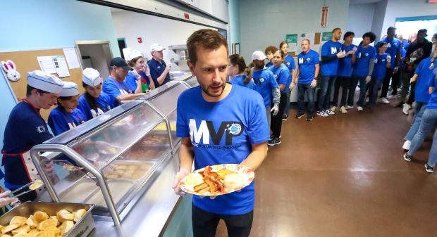 A THANKSGIVING TRADITION — Ryan DeVos, team Managing Director, plates...