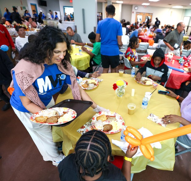 Volunteers serve at the Orlando Magic 33rd Annual Thanksgiving Breakfast in partnership with the Coalition for the Homeless of Central Florida at their downtown campus on Thursday morning. Magic executives, ambassadors and volunteers served a Thanksgiving breakfast to hundreds of residents, continuing a tradition that first began in 1992. (Joe Burbank/Orlando Sentinel)