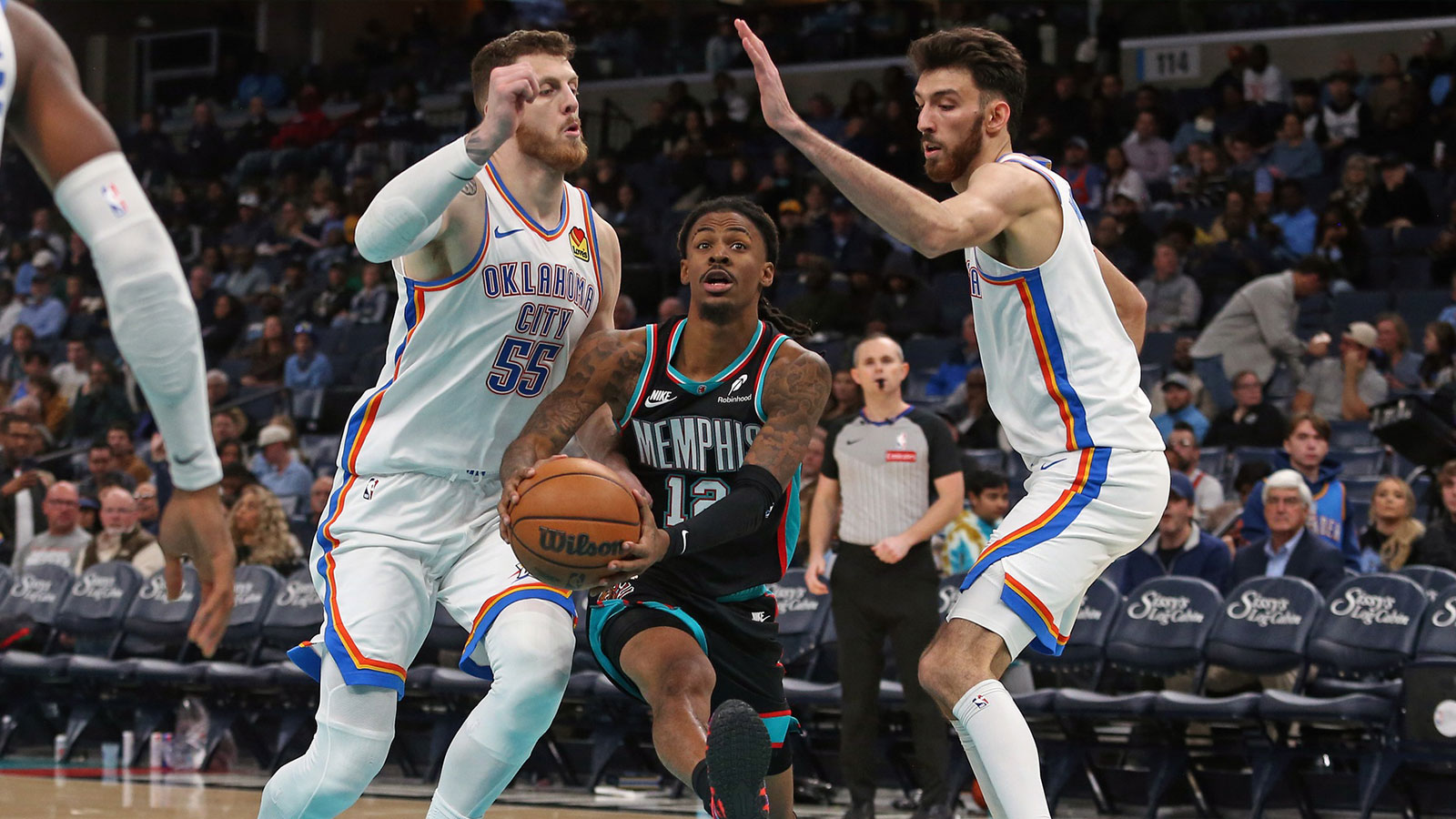 Grizzlies guard Ja Morant (12) drives to the basket between Oklahoma City Thunder center Isaiah Hartenstein (55) and center Chet Holmgren (7) during the third quarter at FedExForum