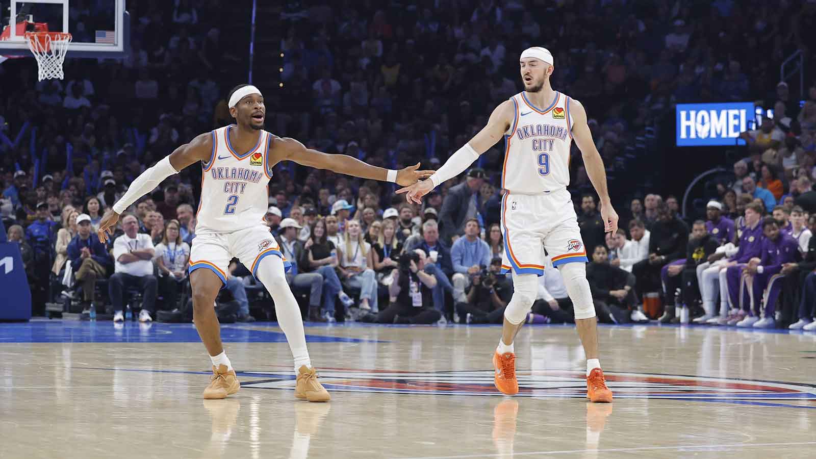 Thunder guard Shai Gilgeous-Alexander (2) and Oklahoma City Thunder guard Alex Caruso (9) celebrate after a basket against the Los Angeles Lakers during the second quarter at Paycom Center