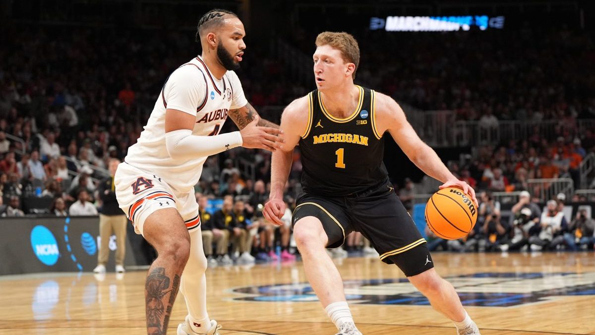 Michigan Wolverines center Danny Wolf (1) drives against Auburn Tigers forward Johni Broome (4) in the first half of a South Regional semifinal of the 2025 NCAA tournament at State Farm Arena.