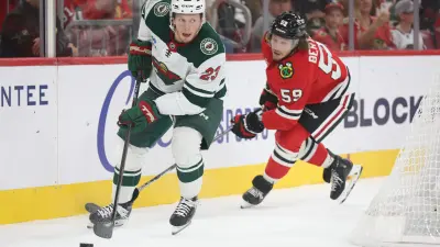 Oct 3, 2025; Chicago, Illinois, USA; Minnesota Wild center Marco Rossi (23) and Chicago Blackhawks left wing Tyler Bertuzzi (59) battle for control of the puck during the first period at United Center. Mandatory Credit: Talia Sprague-Imagn Images