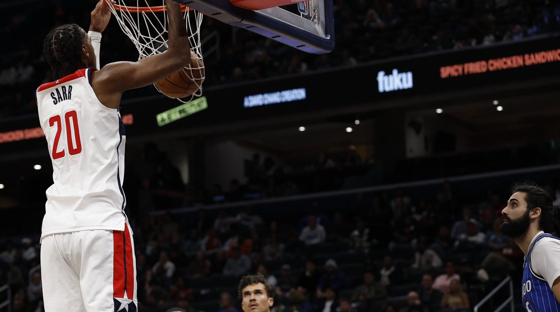 Nov 1, 2025; Washington, District of Columbia, USA; Washington Wizards center Alex Sarr (20) dunks the ball as Orlando Magic center Goga Bitadze (35) looks on in the second half at Capital One Arena. Mandatory Credit: Geoff Burke-Imagn Images