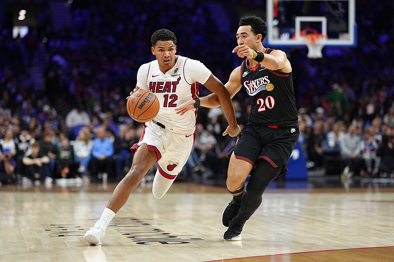 Nov 23, 2025; Philadelphia, Pennsylvania, USA; Miami Heat guard Dru Smith (12) drives against Philadelphia 76ers guard Jared McCain (20) in the first quarter at Xfinity Mobile Arena. Mandatory Credit: Kyle Ross-Imagn Images