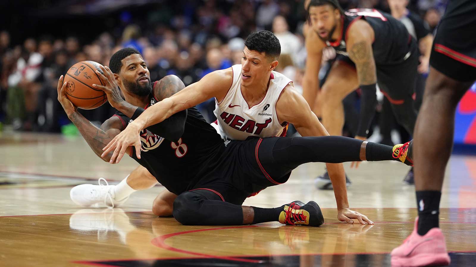 Philadelphia 76ers forward Paul George (8) and Miami Heat forward Simone Fontecchio (0) battle for a loose ball in the second quarter at Xfinity Mobile Arena.