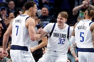 Dallas Mavericks forward Dwight Powell (7) helps forward Cooper Flagg (32) to his feet after...