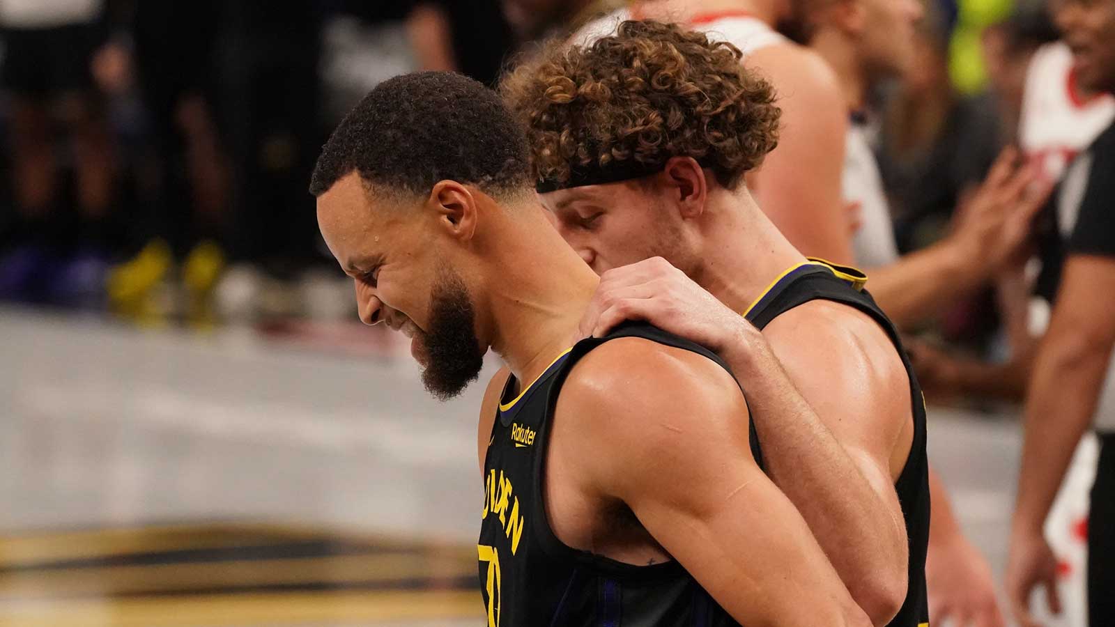 Warriors guard Stephen Curry (30) walks slowly upcourt with guard Brandin Podziemski (2) after a play against the Houston Rockets in the fourth quarter at Chase Center