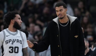 San Antonio Spurs forward Victor Wembanyama, right, talks with teamamte forward Julian Champagnie (30) during the first half of an NBA basketball game against the Sacramento Kings in San Antonio, Sunday, Nov. 16, 2025. (AP Photo/Eric Gay)