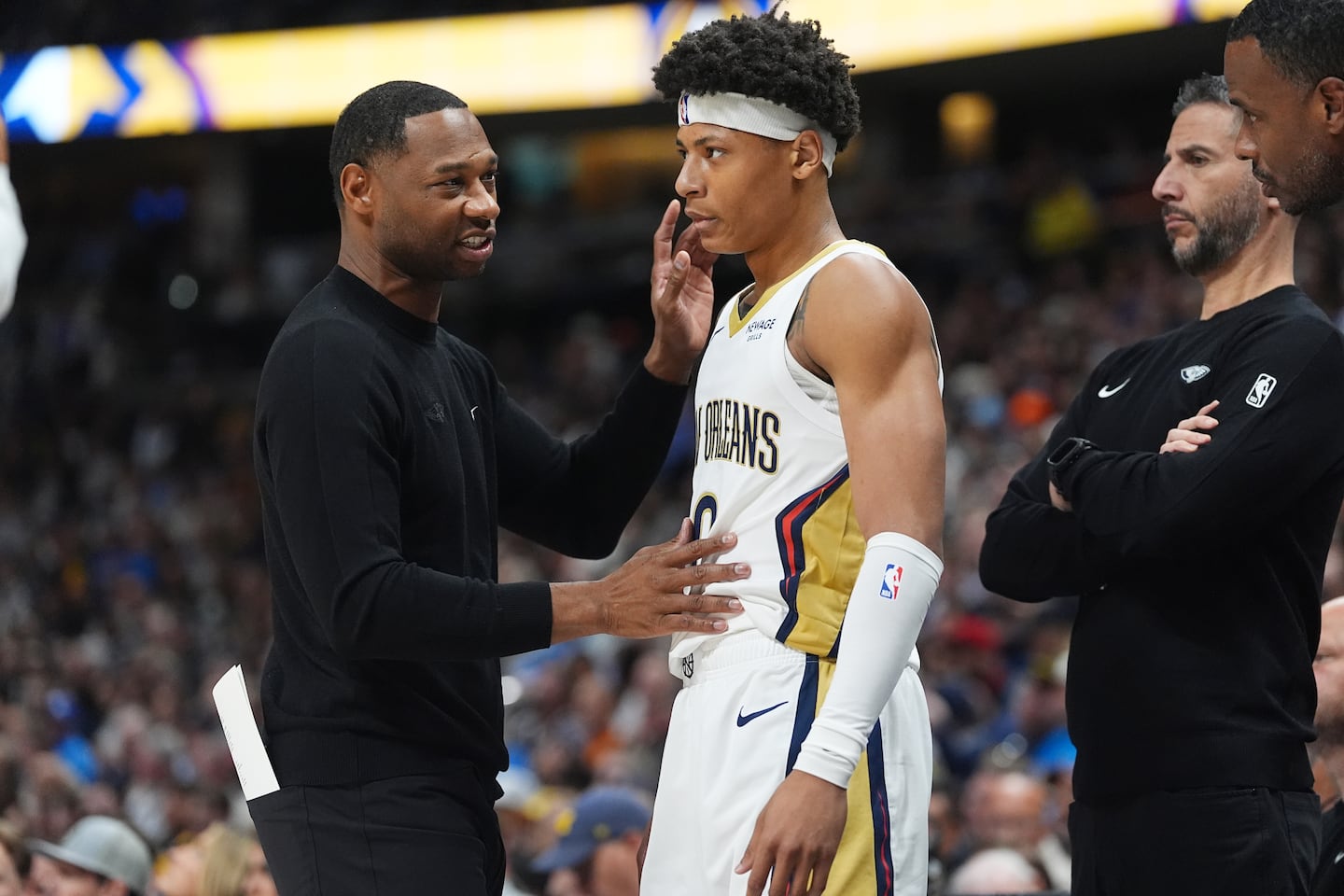 New Orleans Pelicans head coach Willie Green, left, confers with guard Jeremiah Fears, center, as assistant coach James Borrego looks on.