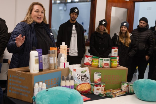 Feed the Children's Julie Laird Davis briefs volunteers and explains the contents of food and hygiene boxes during the YMCA of Greater Boston's Thanksgiving Giveback. (Libby O'Neill/Boston Herald)