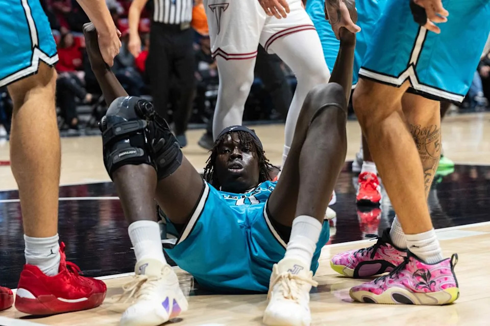 San Diego State forward Magoon Gwath (0) is helped up by teammates during an NCAA Basketball game against Troy, Tuesday November 18, 2025 at Viejas Arena in San Diego, Calif.