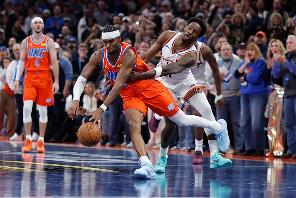 Nov 28, 2025; Oklahoma City, Oklahoma, USA; Phoenix Suns forward Nigel Hayes-Davis (21) fouls Oklahoma City Thunder guard Shai Gilgeous-Alexander (2) during the second half at Paycom Center. Mandatory Credit: Alonzo Adams-Imagn Images