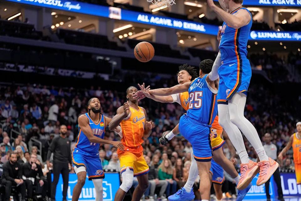 Nov 15, 2025; Charlotte, North Carolina, USA; Charlotte Hornets guard KJ Simpson (25) runs into Oklahoma City Thunder guard Ajay Mitchell (25) driving to the basket during the first half at Spectrum Center. Mandatory Credit: Jim Dedmon-Imagn Images