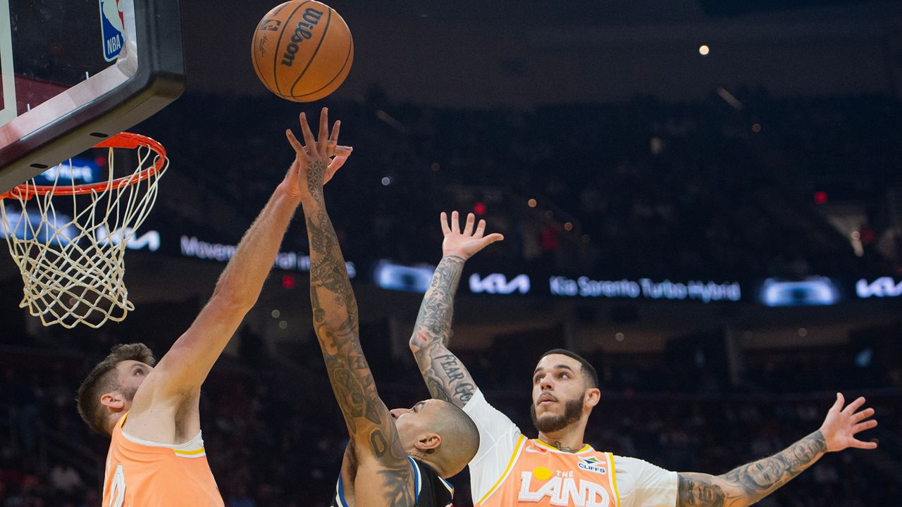 Milwaukee Bucks' Kyle Kuzma, center, shoots over Cleveland Cavaliers' Dean Wade, left, and Lonzo Ball (2) during the first half of an NBA basketball game in Cleveland, Monday, Nov. 17, 2025. (AP Photo/Phil Long)