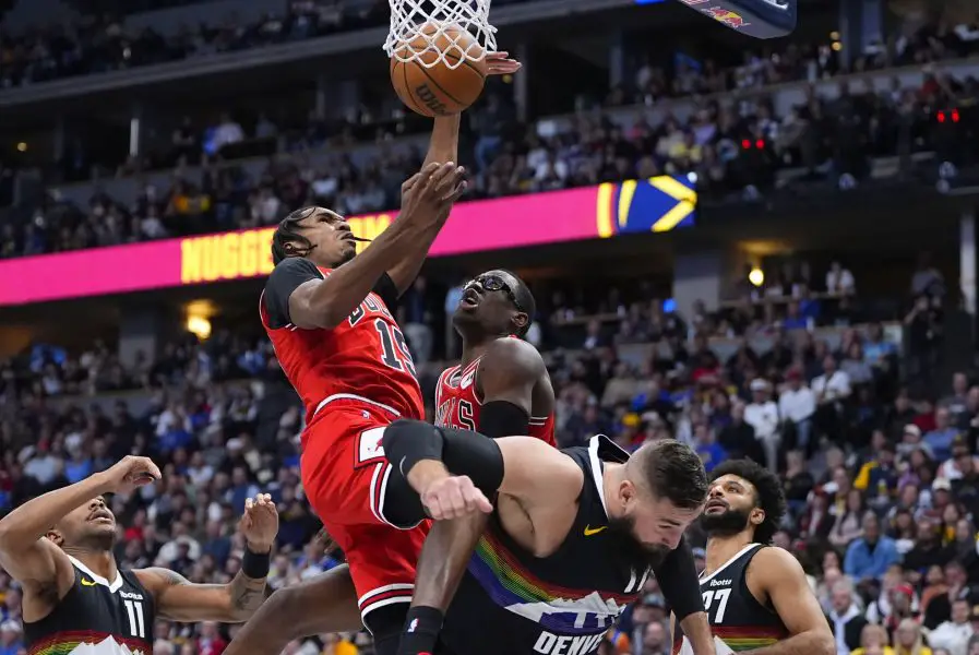 Nov 17, 2025; Denver, Colorado, USA; Chicago Bulls forward Julian Phillips (15) grabs a rebound over Denver Nuggets center Jonas Valanciunas (17) in the second quarter at Ball Arena. Mandatory Credit: Ron Chenoy-Imagn Images