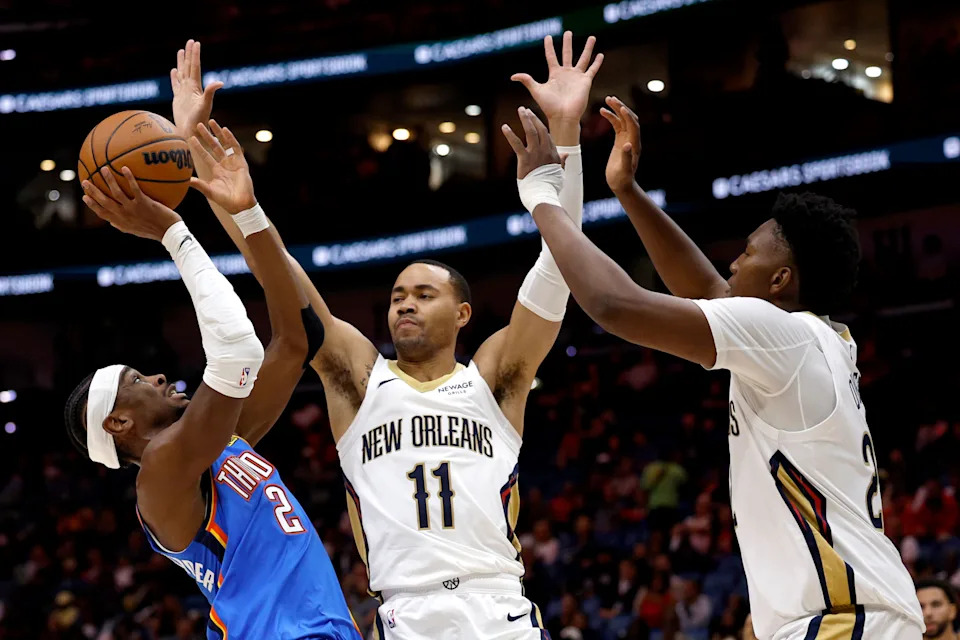 NEW ORLEANS, LOUISIANA - NOVEMBER 17: Shai Gilgeous-Alexander #2 of the Oklahoma City Thunder shoots over Bryce McGowens #11 and Derik Queen #22 of the New Orleans Pelicans during the first quarter of the NBA game at Smoothie King Center on November 17, 2025 in New Orleans, Louisiana. NOTE TO USER: User expressly acknowledges and agrees that, by downloading and or using this photograph, User is consenting to the terms and conditions of the Getty Images License Agreement. (Photo by Sean Gardner/Getty Images)