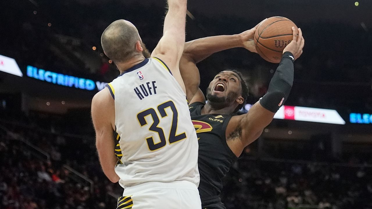 Cleveland Cavaliers guard Donovan Mitchell, right, looks to shoot as Indiana Pacers center Jay Huff (32) defends in the second half of an NBA Cup basketball game Friday, Nov. 21, 2025, in Cleveland. (AP Photo/Sue Ogrocki)