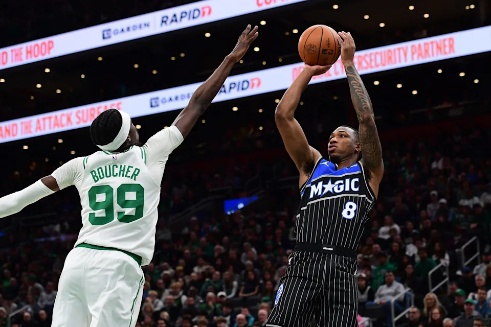 Nov 23, 2025; Boston, Massachusetts, USA; Orlando Magic forward Jamal Cain (8) shoots the ball while Boston Celtics forward Chris Boucher (99) defends during the first half at TD Garden. Mandatory Credit: Bob DeChiara-Imagn Images