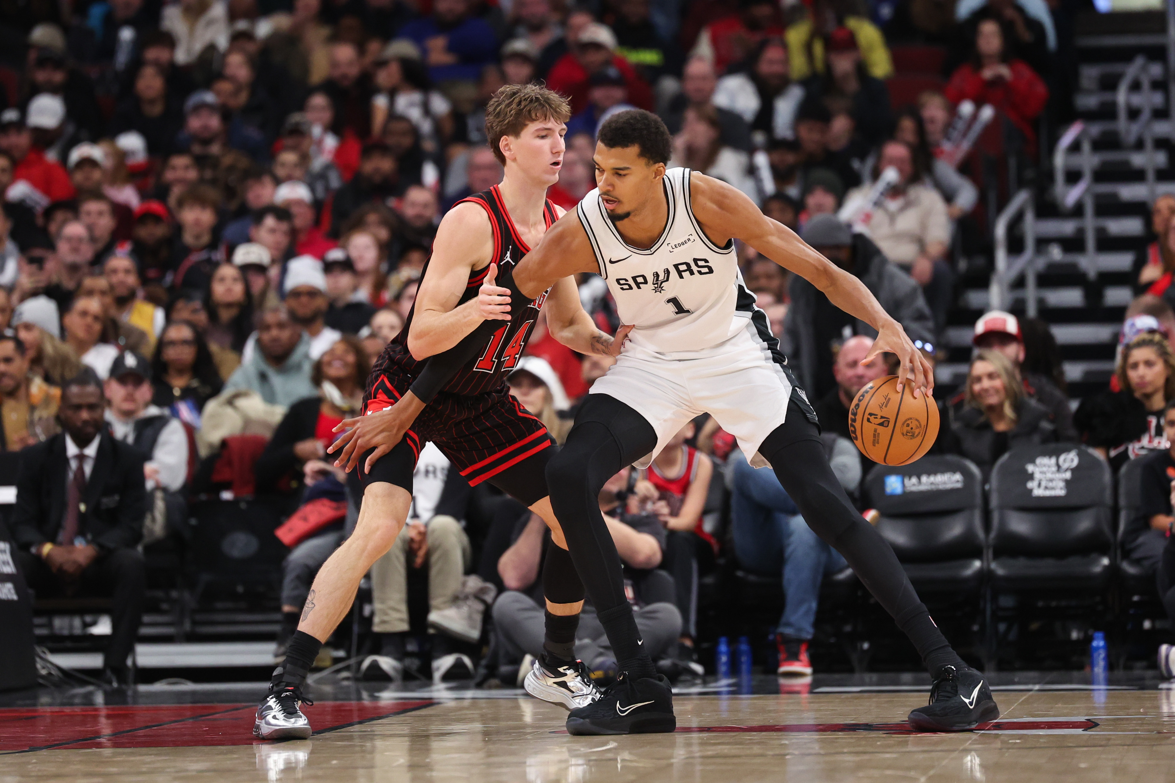 Chicago Bulls forward Matas Buzelis (14) guards San Antonio Spurs forward Victor Wembanyama (1) during the second quarter at the United Center on Monday, Nov. 10, 2025, in Chicago. (Armando L. Sanchez/Chicago Tribune)