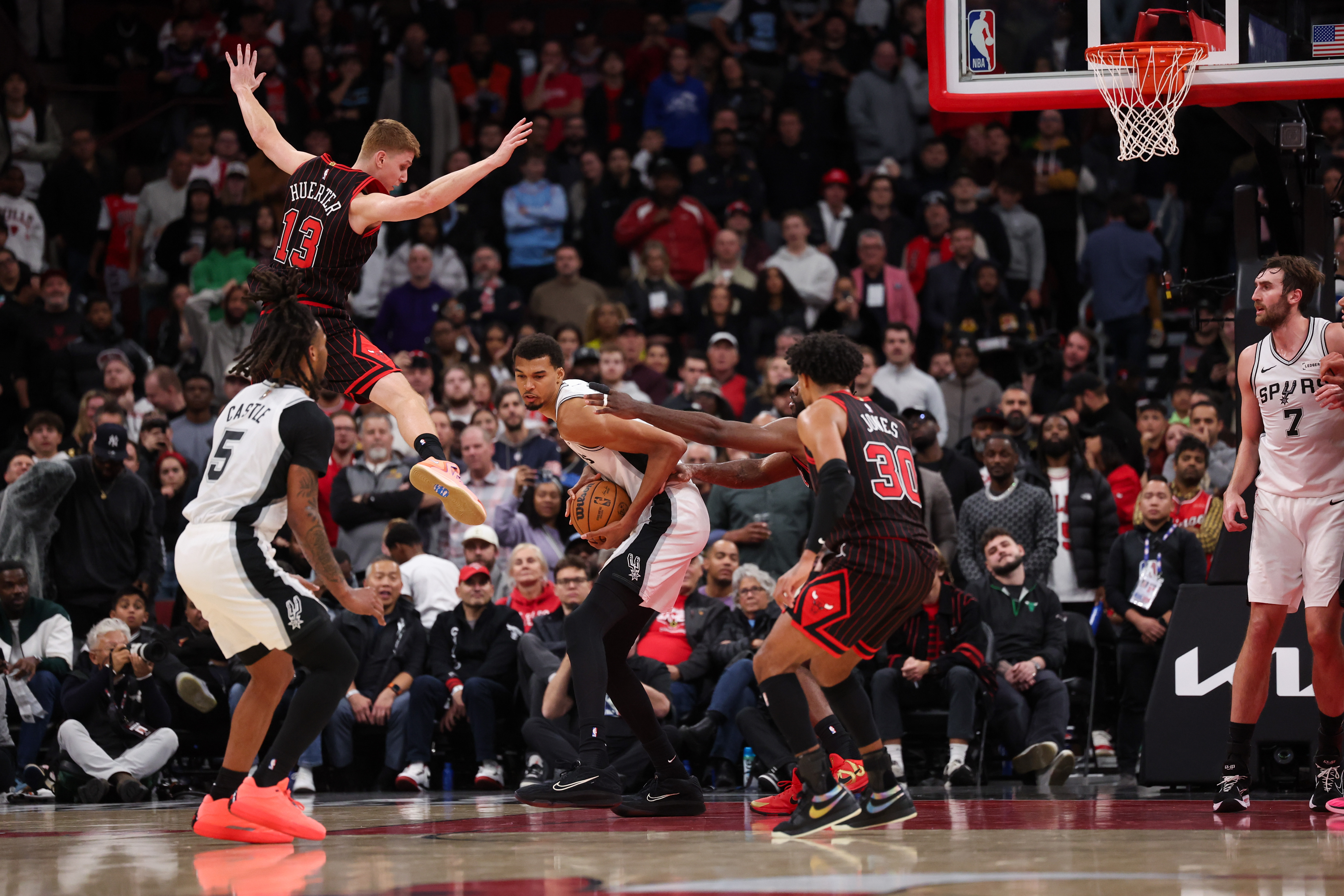 Chicago Bulls guard Kevin Huerter (13) jumps in the air while guarding San Antonio Spurs forward Victor Wembanyama (1) during the fourth quarter at the United Center on Monday, Nov. 10, 2025, in Chicago. (Armando L. Sanchez/Chicago Tribune)