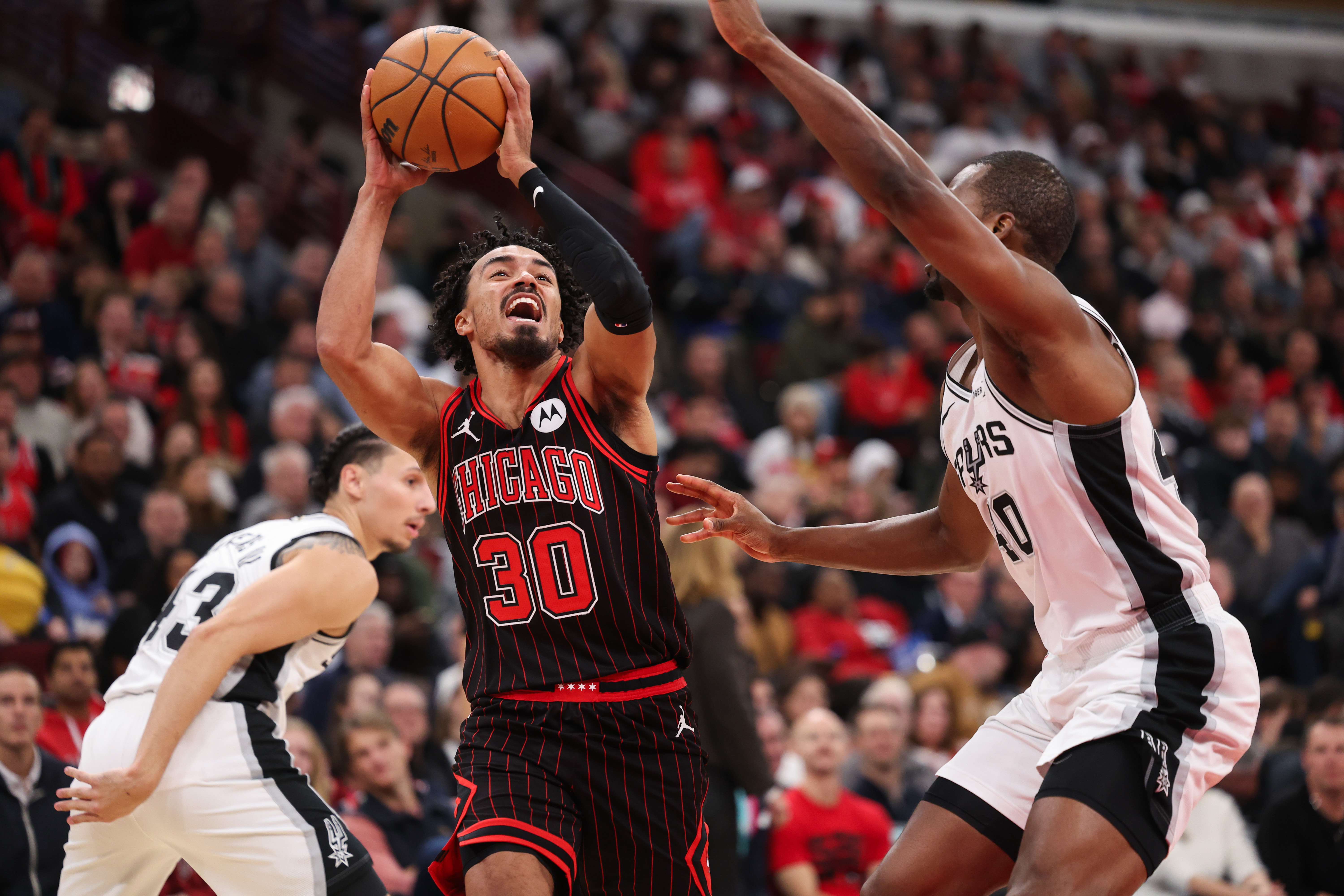 Chicago Bulls guard Tre Jones (30) drives against San Antonio Spurs forward Harrison Barnes (40) during the second quarter at the United Center on Monday, Nov. 10, 2025, in Chicago. (Armando L. Sanchez/Chicago Tribune)