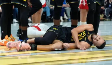 Stephen Curry of the Golden State Warriors lays on the floor in pain after colliding with Amen Thompson of the Houston Rockets.