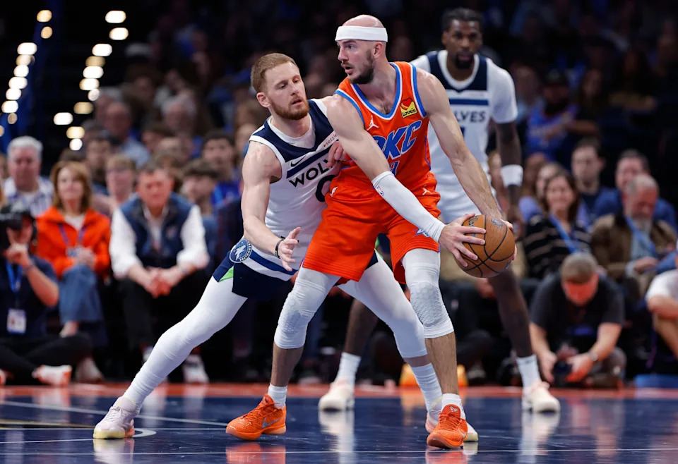 Nov 26, 2025; Oklahoma City, Oklahoma, USA; Minnesota Timberwolves guard Donte DiVincenzo (0) defends Oklahoma City Thunder guard Alex Caruso (9) during the second half at Paycom Center. Mandatory Credit: Alonzo Adams-Imagn Images