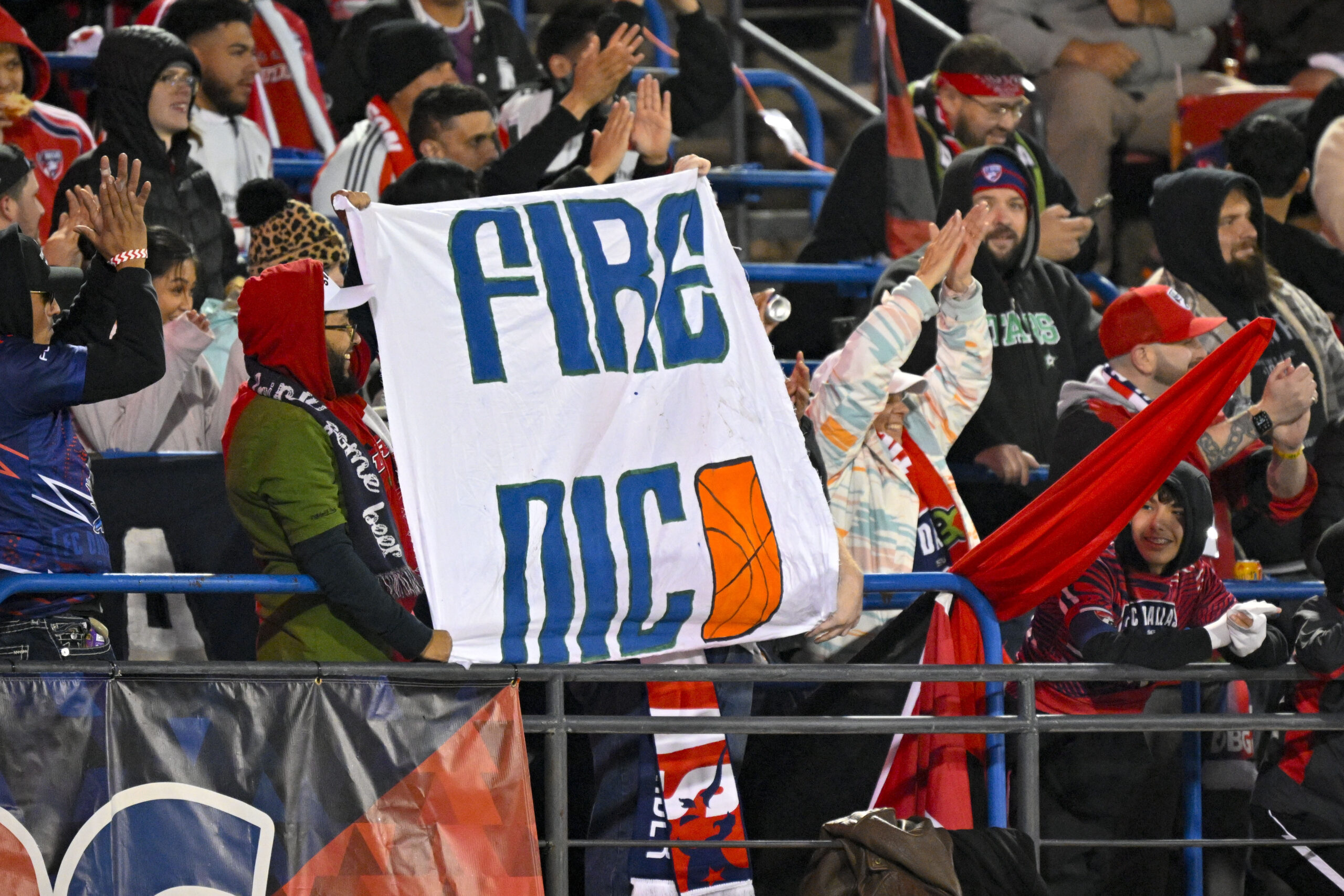 Fans hold up a Fire Nico sign for Dallas Mavericks general manager Nico Harrison.