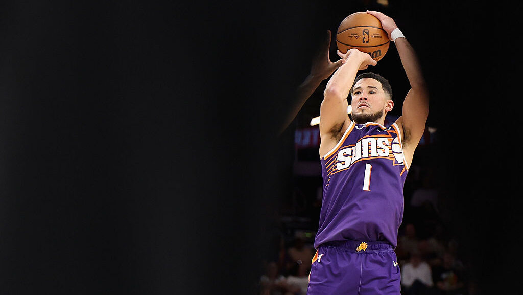 Devin Booker #1 of the Phoenix Suns attempts a shot against the Memphis Grizzlies during the fourth...