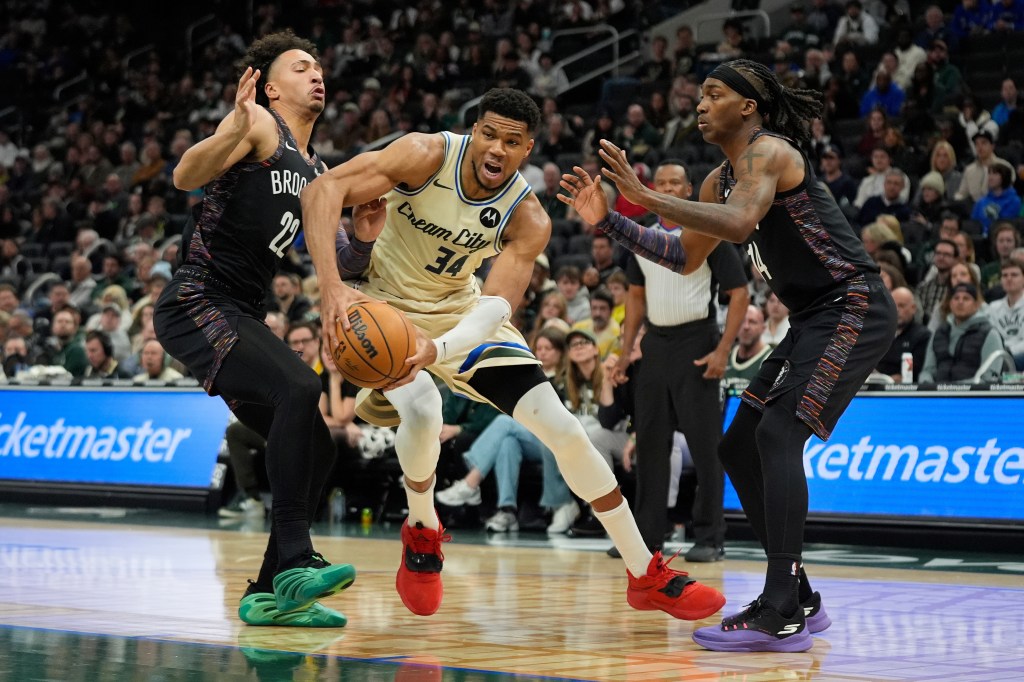Giannis Antetokounmpo (34) driving to the basket against Jalen Wilson (22) and Terance Mann (14).